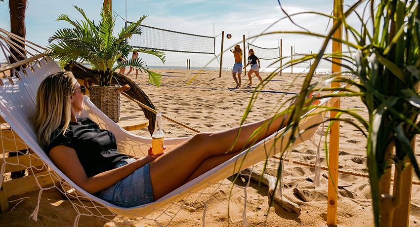  Girl is lying in the hammock on the beach